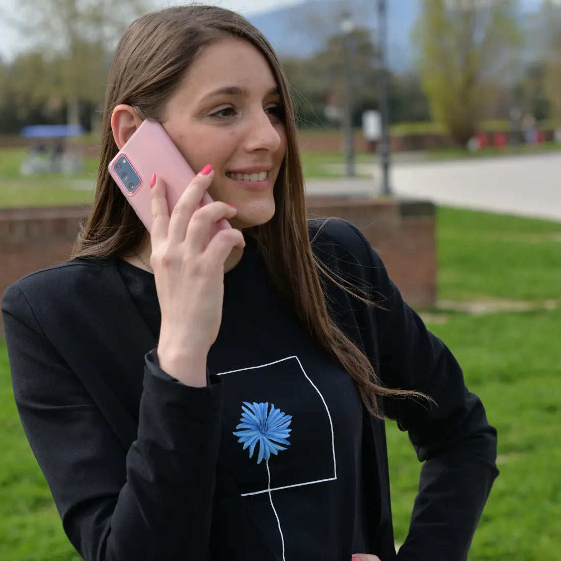 Ragazza con cellulare indossa Fiordaliso, la maglietta organica Binove